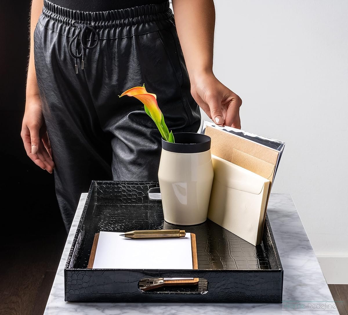 Black decorative serving tray used as a desk and console catchall